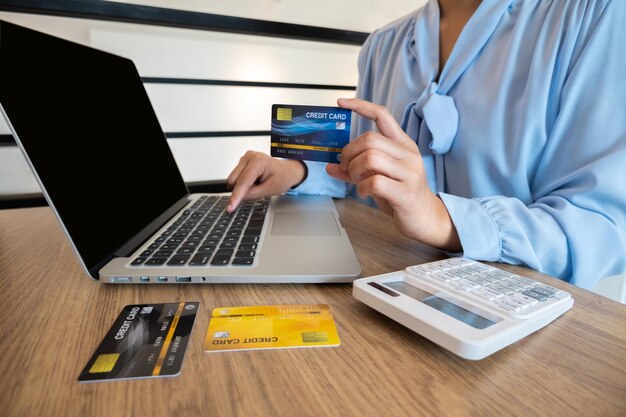 Sección media de una mujer usando una computadora portátil en la mesa