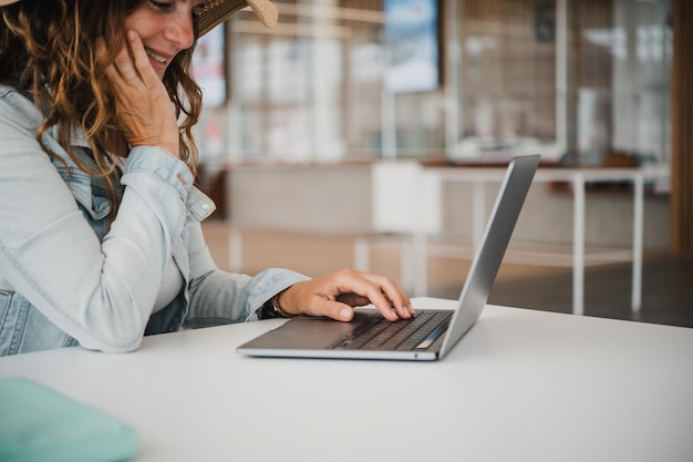 Sección media de una mujer usando una computadora portátil en la mesa