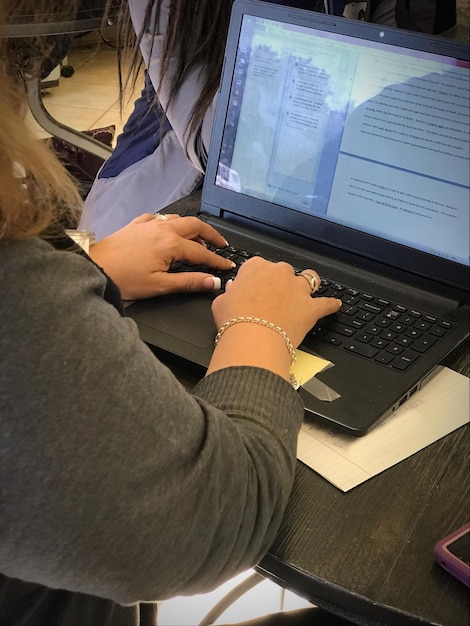 Foto sección media de una mujer usando una computadora portátil