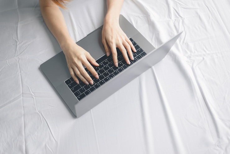 Foto sección media de una mujer usando el teléfono móvil en la cama