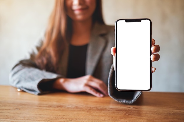 Foto sección media de una mujer usando un teléfono móvil en la mesa