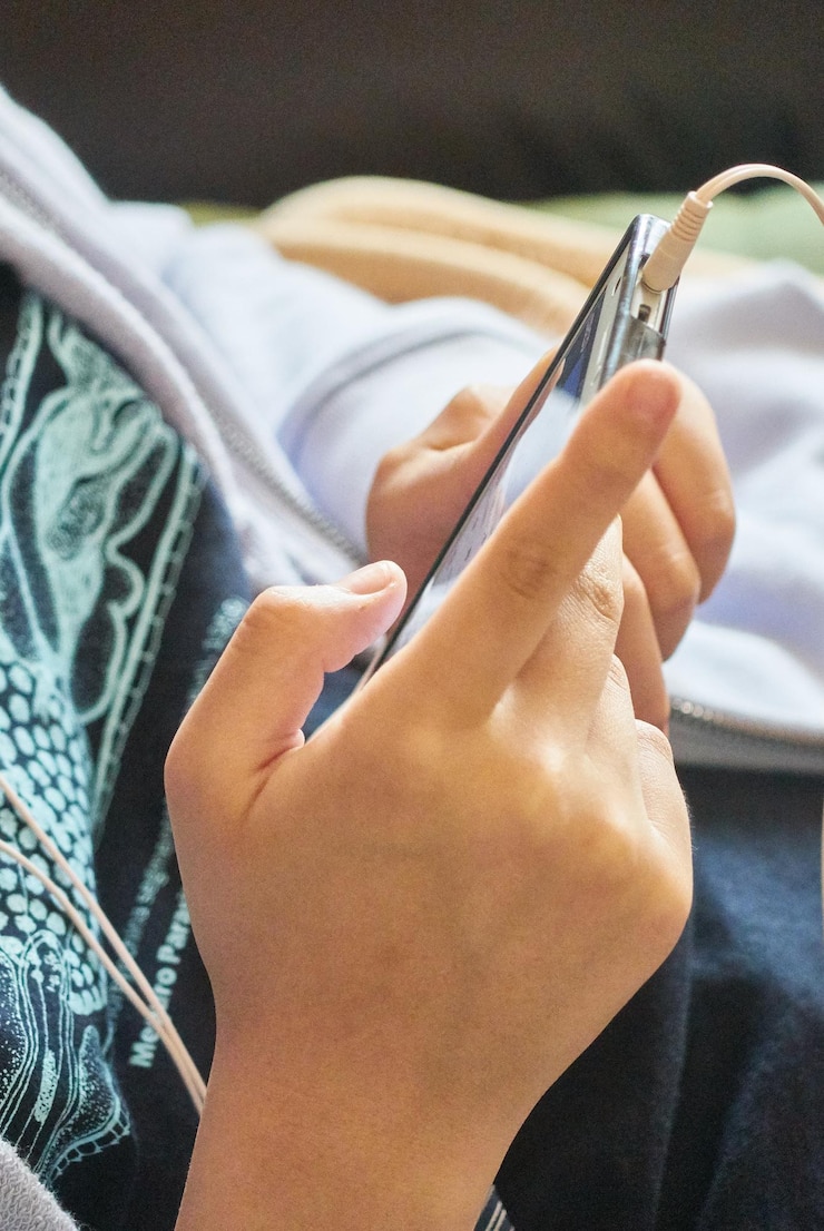 Foto sección media de una mujer usando el teléfono móvil mientras está sentada en casa