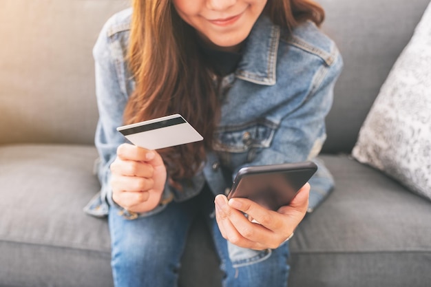 Sección media de una mujer usando un teléfono móvil
