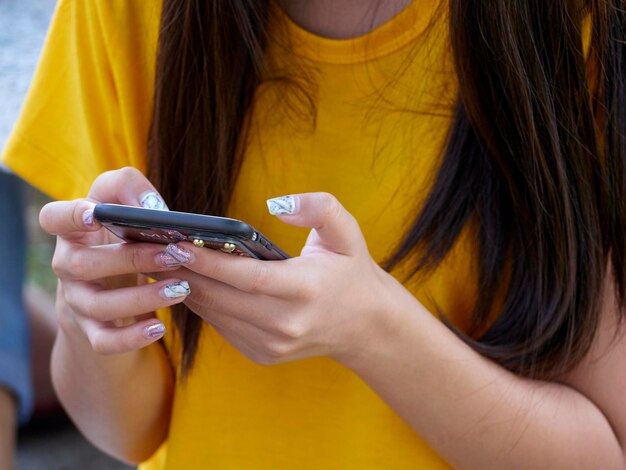 Sección media de una mujer usando un teléfono móvil