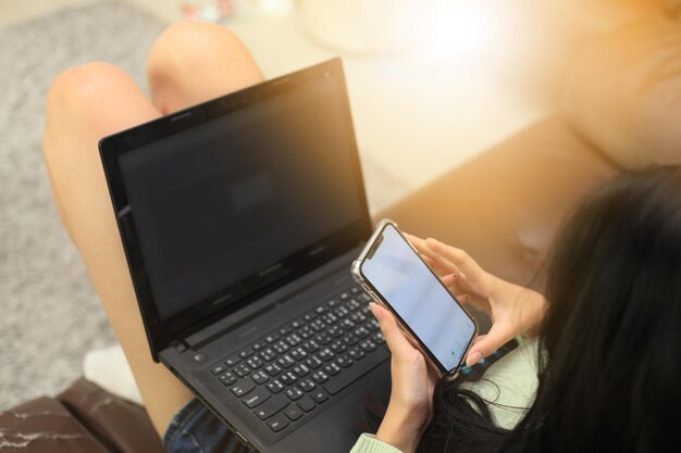 Foto sección media de una mujer usando un teléfono móvil.