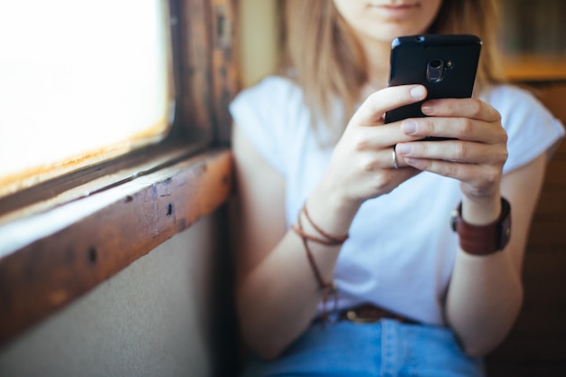 Sección media de una mujer usando un teléfono móvil