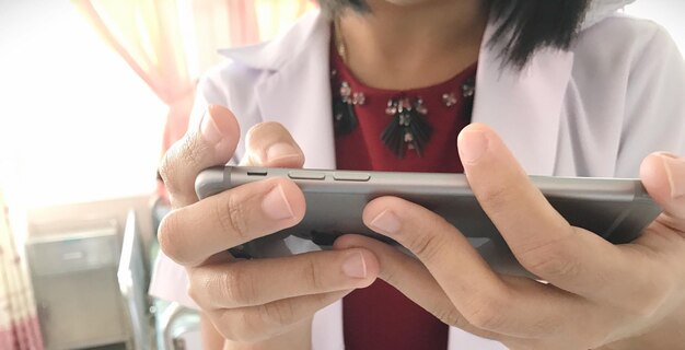 Foto sección media de una mujer usando un teléfono móvil