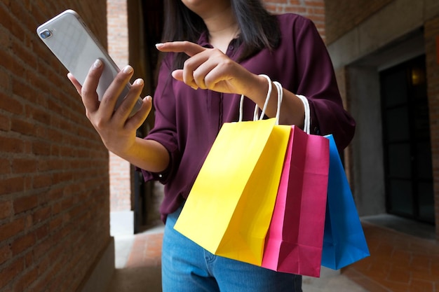 Foto sección media de una mujer usando un teléfono móvil