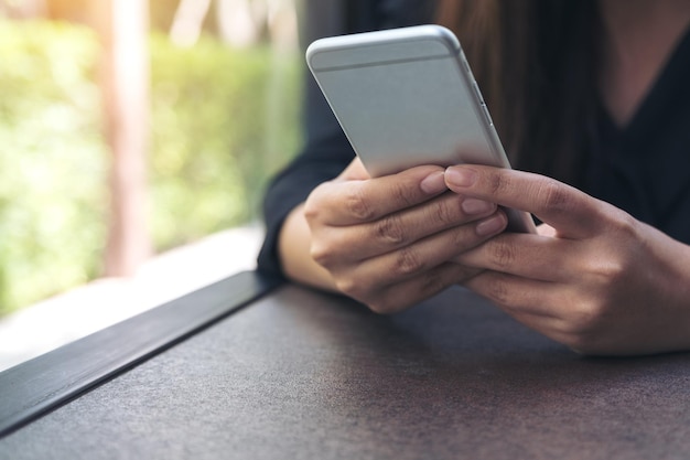 Sección media de una mujer usando un teléfono móvil