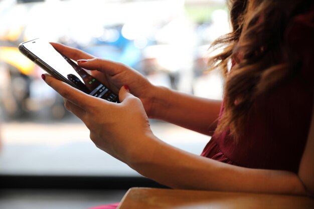 Foto sección media de una mujer usando un teléfono móvil