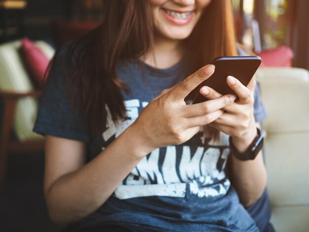 Sección media de una mujer usando un teléfono móvil