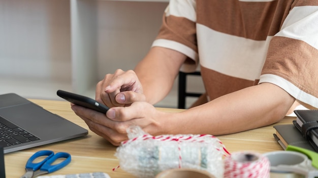 Sección media de una mujer usando un teléfono móvil