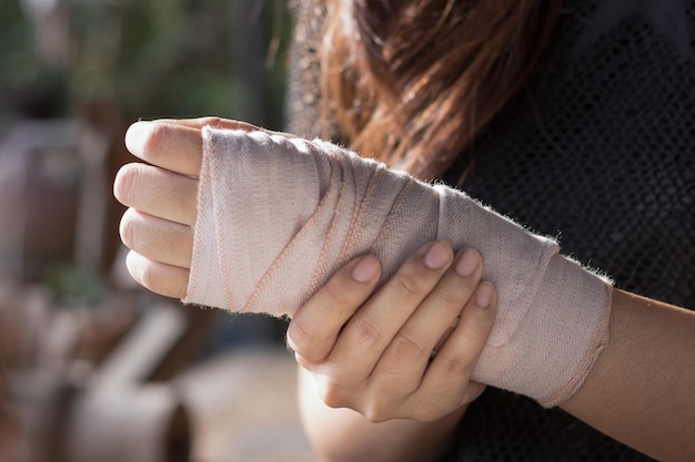 Sección media de una mujer con un vendaje envuelto en la mano