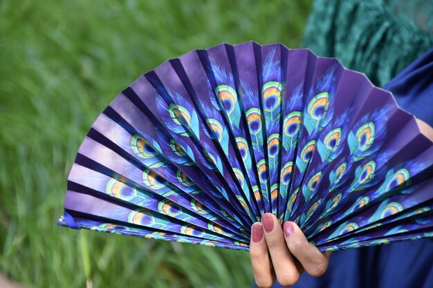 Foto sección media de una mujer con un ventilador en la mano