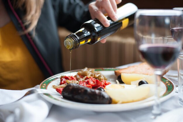 Sección media de una mujer vertiendo salsa en la comida