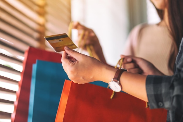 Sección media de mujeres con bolsas de compras y tarjetas de crédito