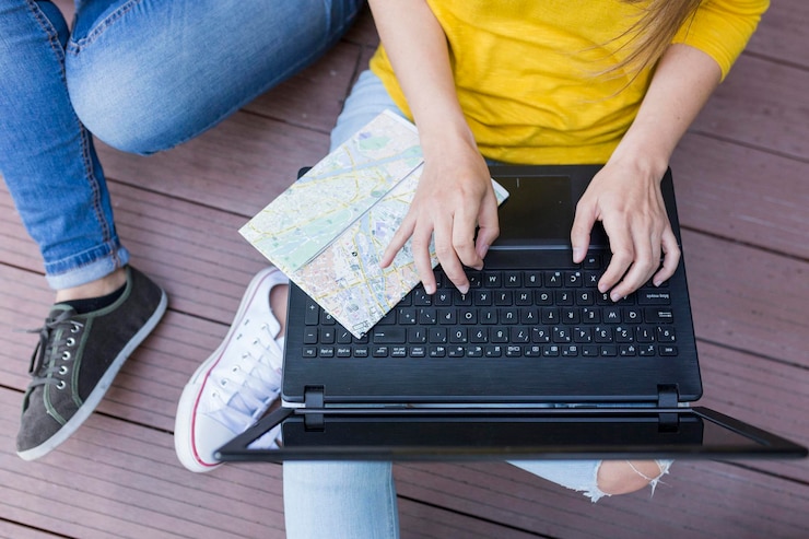 Foto sección media de mujeres usando una computadora portátil mientras están sentadas en madera