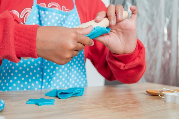 Foto sección media de una niña jugando con arcilla en la mesa