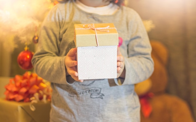 Foto sección media de una niña con un regalo de navidad en casa