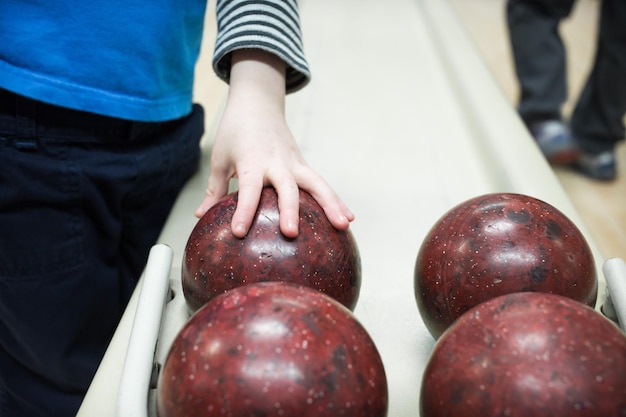 Foto sección media de un niño con bolas de bolos