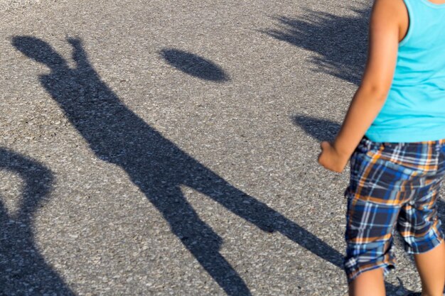 Foto sección media de un niño de pie en la carretera