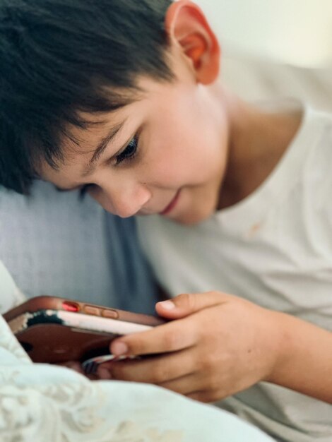 Sección media de un niño usando un teléfono móvil