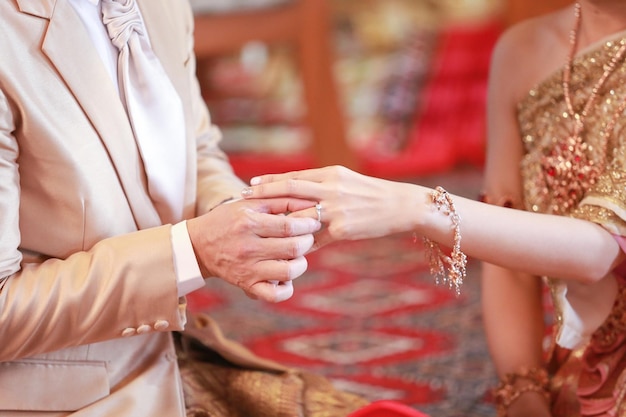 Sección media de la novia y el novio intercambiando anillos durante la ceremonia de bodas