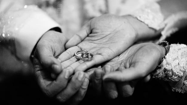 Sección media de la novia y el novio sosteniendo los anillos de bodas