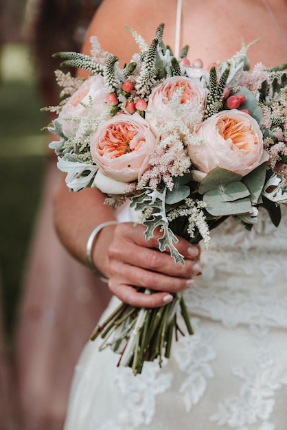 Sección media de la novia sosteniendo un ramo de flores