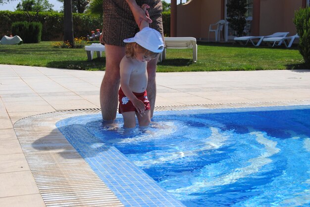 Foto sección media de padre con hijo en la piscina