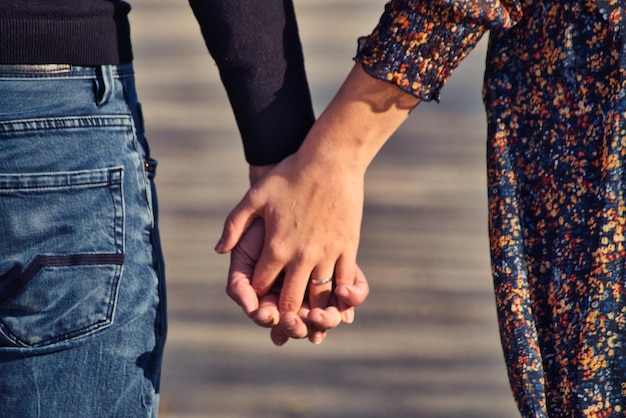 Foto sección media de una pareja que se sostiene de la mano