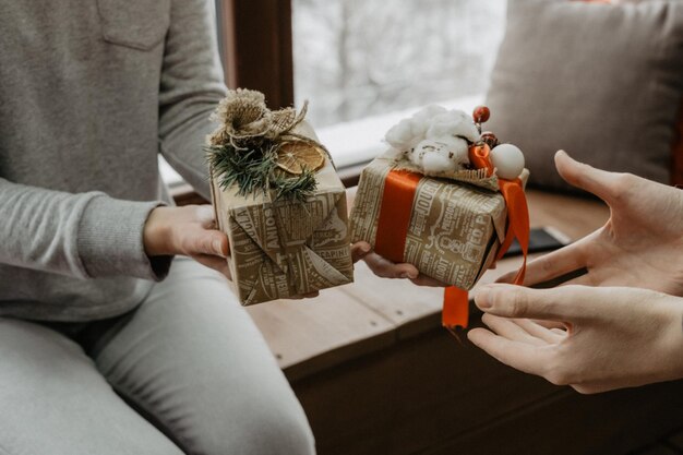 Sección media de una pareja con regalos de Navidad