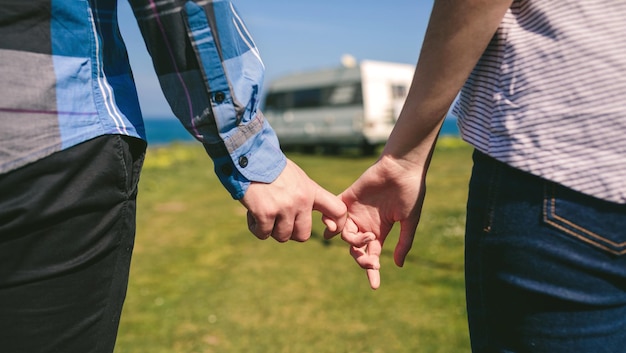 Foto sección media de una pareja tomándose de la mano en la playa