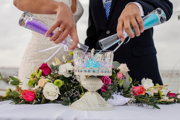 Foto sección media de una pareja vertiendo una bebida en un recipiente en la mesa