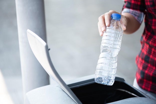 Foto sección media de una persona arrojando una botella de agua