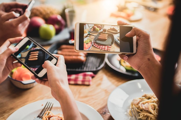 Foto sección media de una persona fotografiando con un teléfono móvil en la mesa