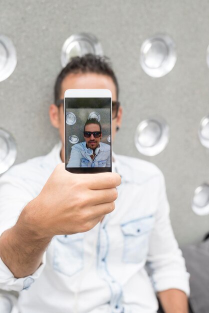 Foto sección media de una persona fotografiando con un teléfono móvil