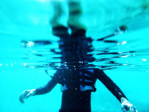 Foto sección media de una persona nadando bajo el agua