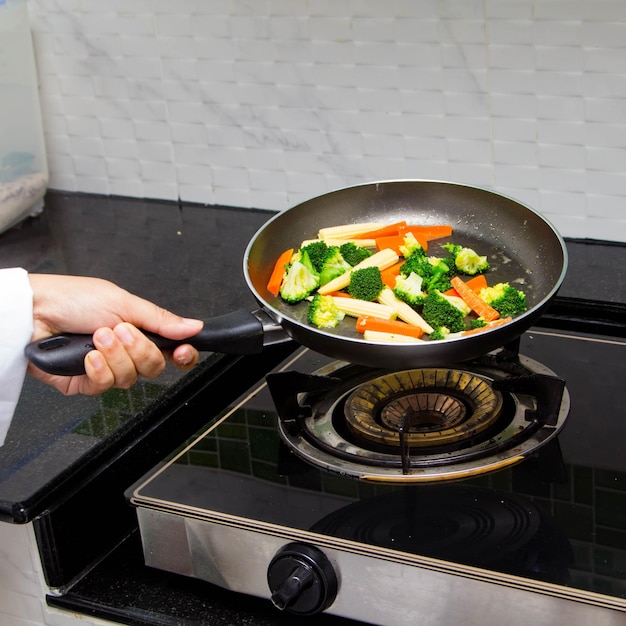 Foto sección media de una persona preparando comida en la cocina en casa