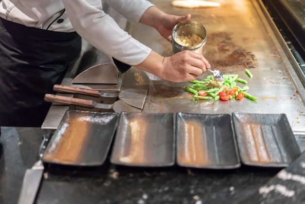 Sección media de una persona preparando comida en la cocina