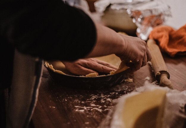 Foto sección media de una persona preparando comida en la cocina