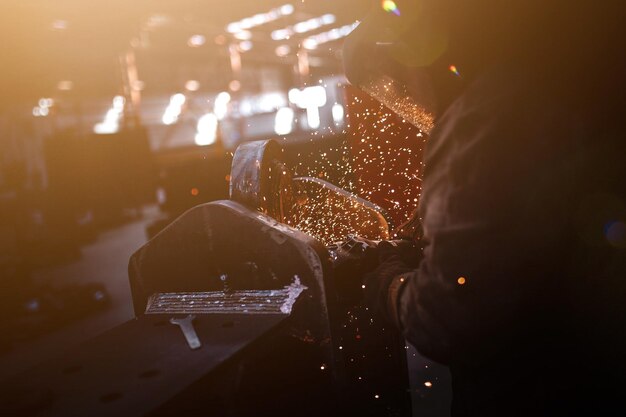 Foto sección media de una persona que trabaja con metal en un taller