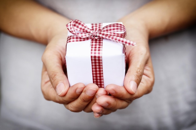 Foto sección media de una persona sosteniendo una caja de regalos.