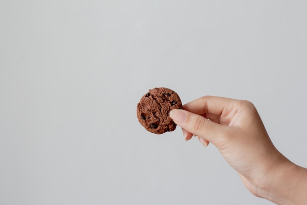 Foto sección media de una persona sosteniendo helado contra un fondo blanco