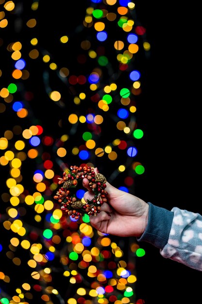 Foto sección media de una persona sosteniendo luces navideñas iluminadas