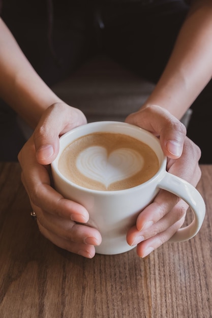 Sección media de una persona sosteniendo una taza de café