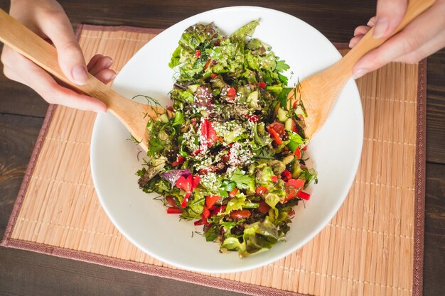 Foto sección media de una persona sosteniendo verduras en un plato