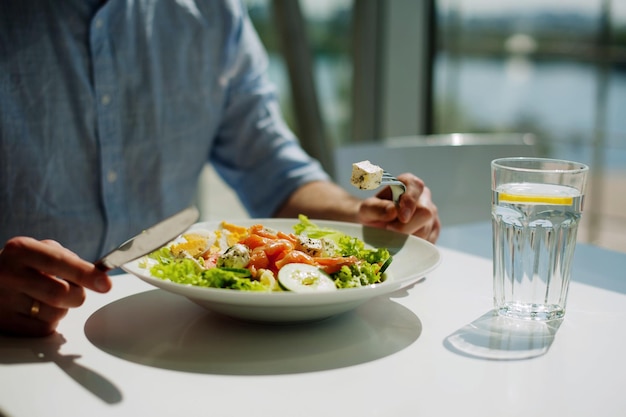 Sección media de una persona con un tenedor en un restaurante