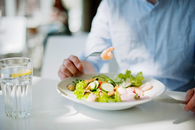 Sección media de una persona con un tenedor en un restaurante