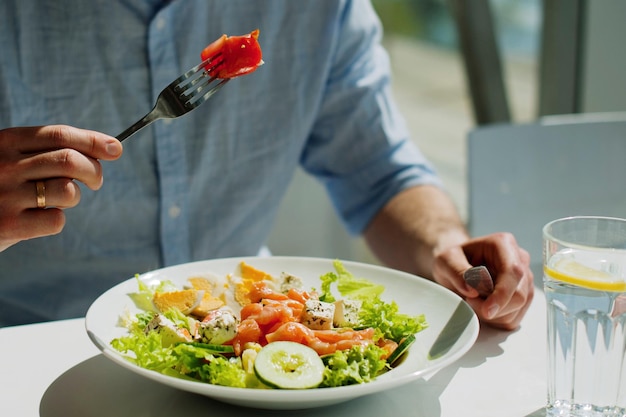Sección media de una persona con un tenedor en un restaurante